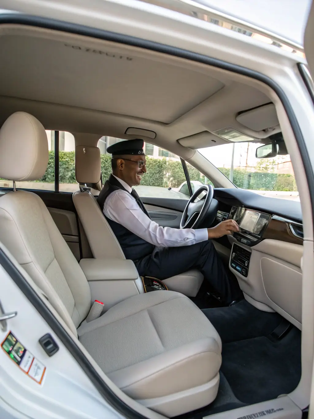 Inside a taxi, showing a comfortable and clean interior with a focus on the spacious seating and climate control. A professional driver is visible in the background.